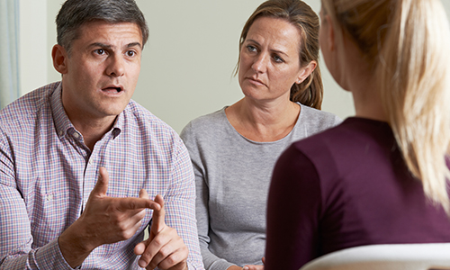 Members Of Support Group Sitting In Chairs Having Meeting