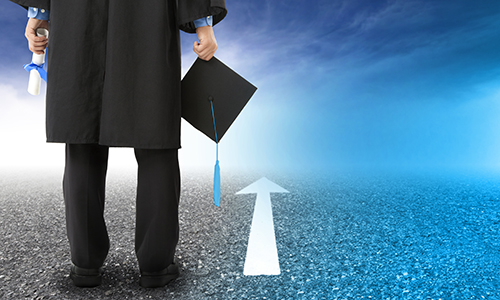 graduate standing on the road and forward arrow